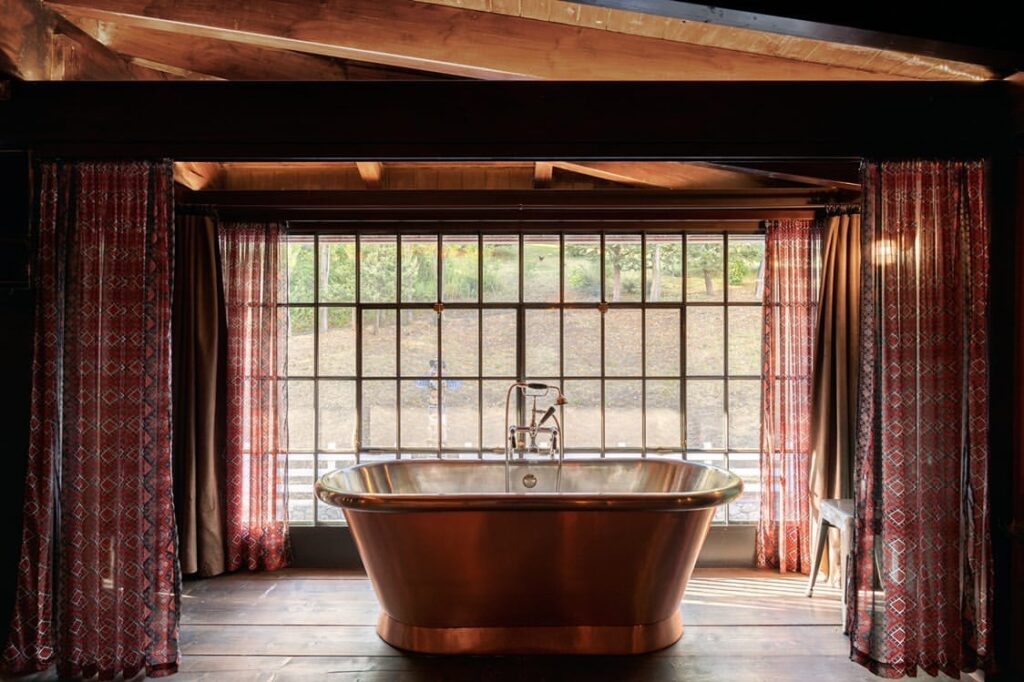 copper roll top bath in a elegant room with a wide window