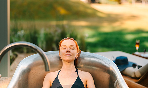 woman relaxing in an outdoor bath by William Holland